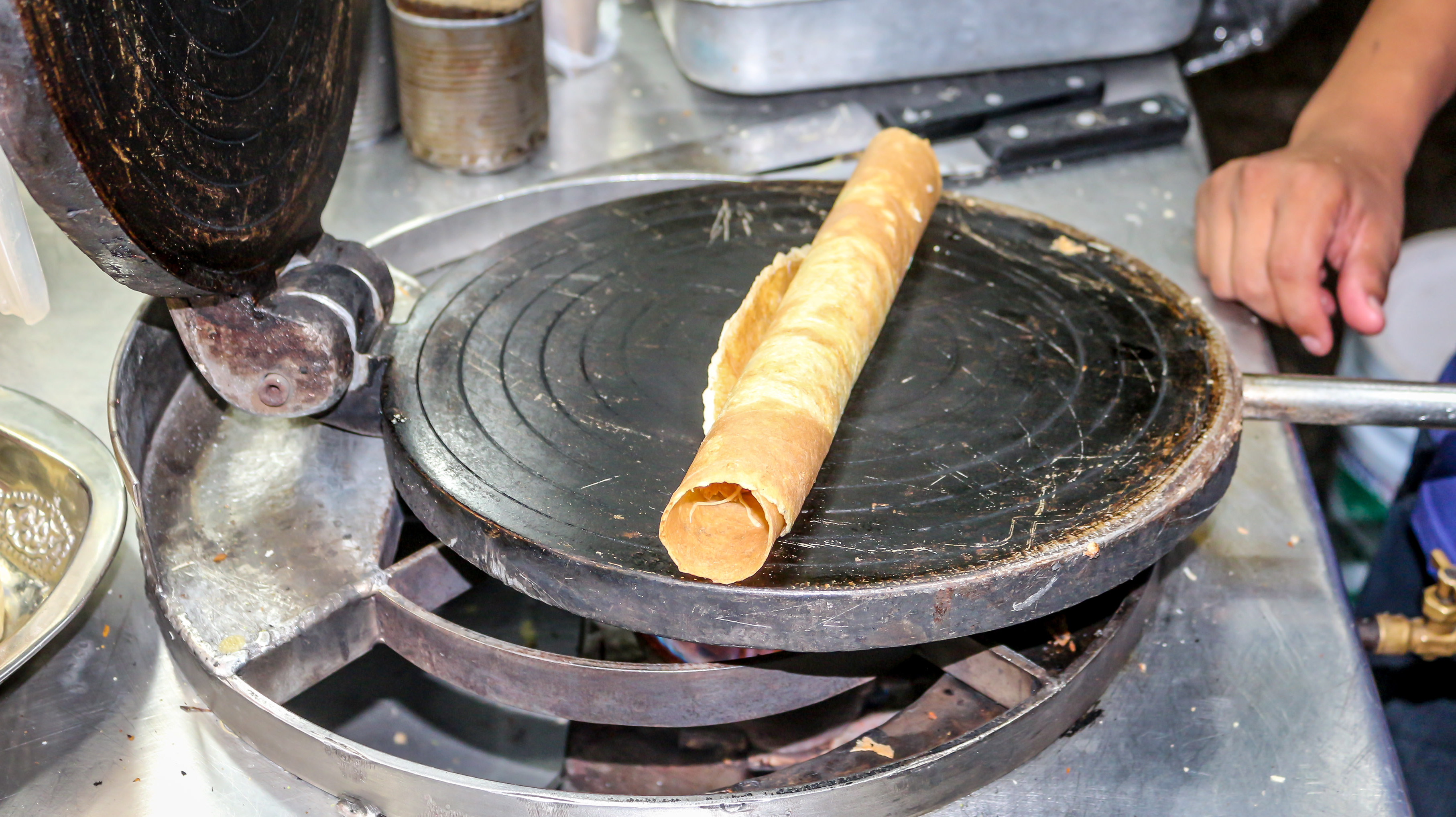Marquesita rolled up and sitting on waffle iron