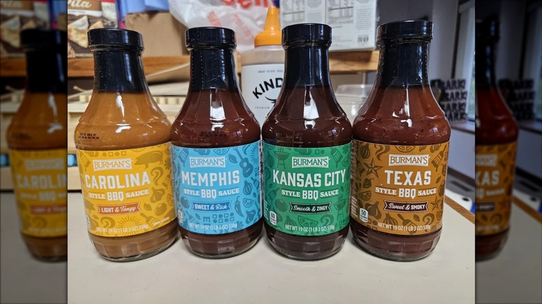 Four bottles of Burman's BBQ sauce on kitchen counter