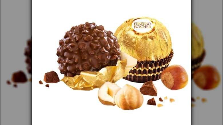 wrapped and unwrapped Ferrero Rocher chocolate on white background