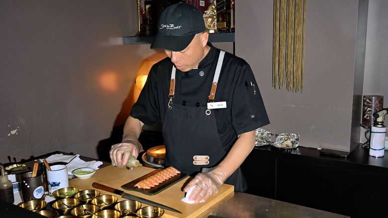 Sushi chef preparing a plate of nigiri