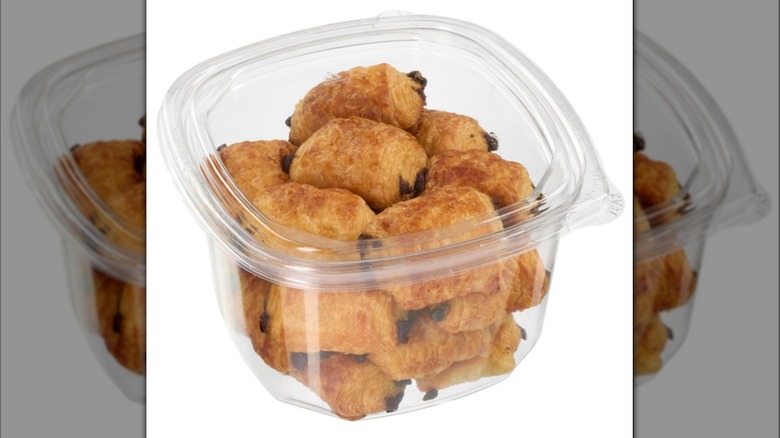 Clear plastic tub of Kirkland Signature Mini Pains Au Chocolat on white background