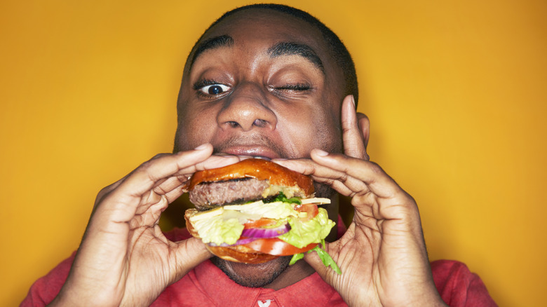 A man holding a burger with both hands