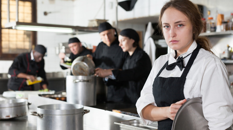 Tired and upset waitress in kitchen of restaurant