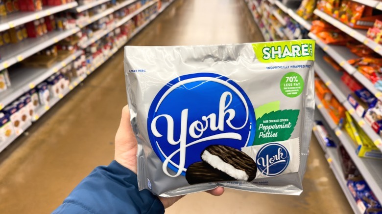 A hand holding a shareable bag of York Peppermint Patties.