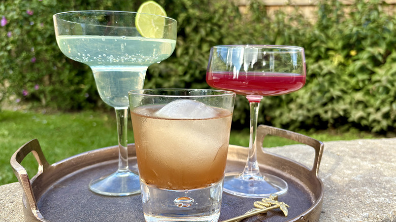 A tray serving three different flavors of poured cocktails