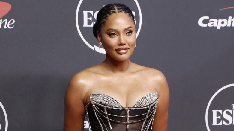 Ayesha Curry wearing a gown and posing at a red carpet event