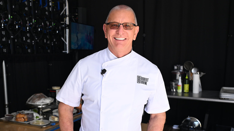 Robert Irvine wearing white chefs coat and smiling