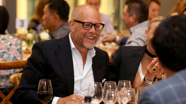 Alton Brown sitting at a banquet table