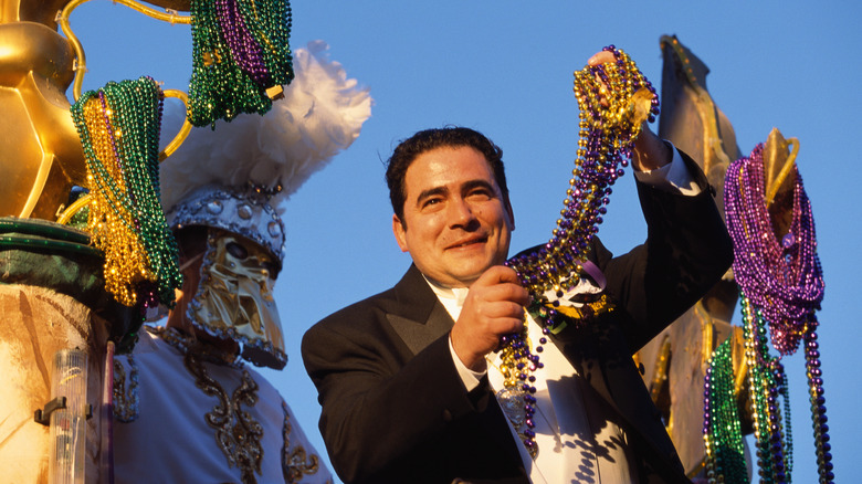 Emeril Lagasse holding up beads at Mardi Gras