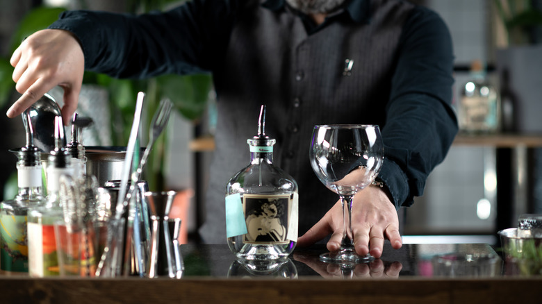 Bartender initiates the artful process of preparing a delightful gin and tonic