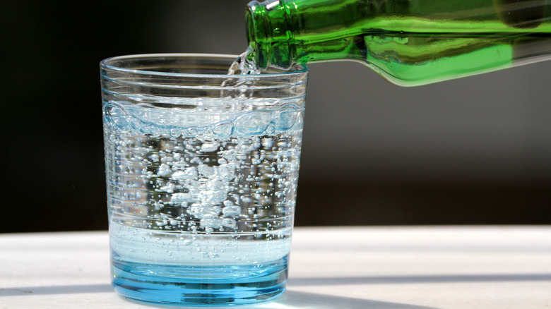 Pouring cold sparkling water in a glass