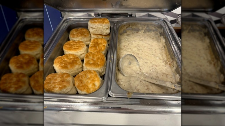 Biscuits and gravy in silver platters with a large serving ladle