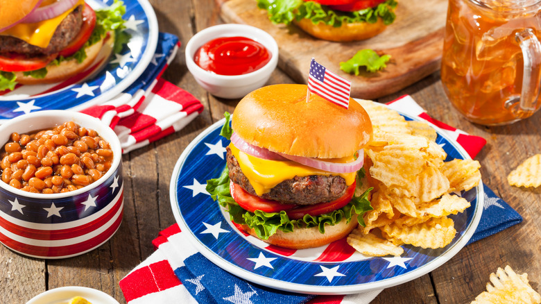 Hamburgers, baked beans, and ridged chips, served on patriotic U.S. flag plates