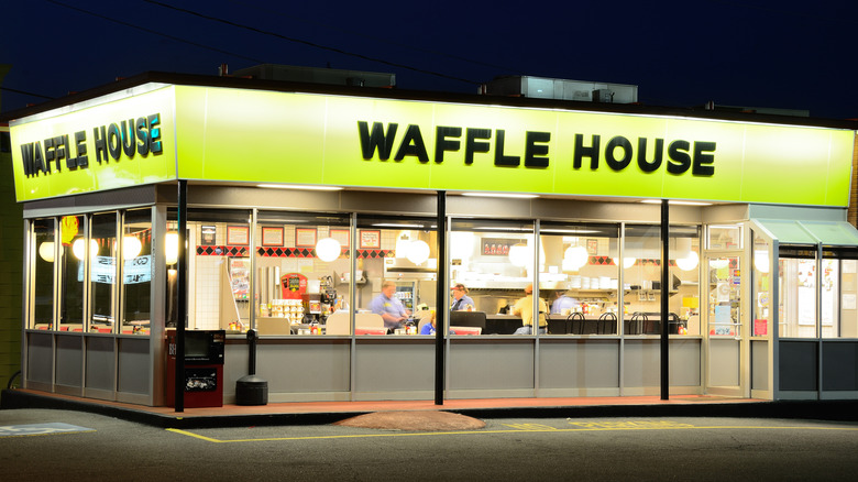 A small Waffle House lit up at night, viewed from the outside