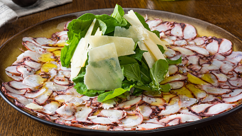 Octopus carpaccio topped with cheese shavings