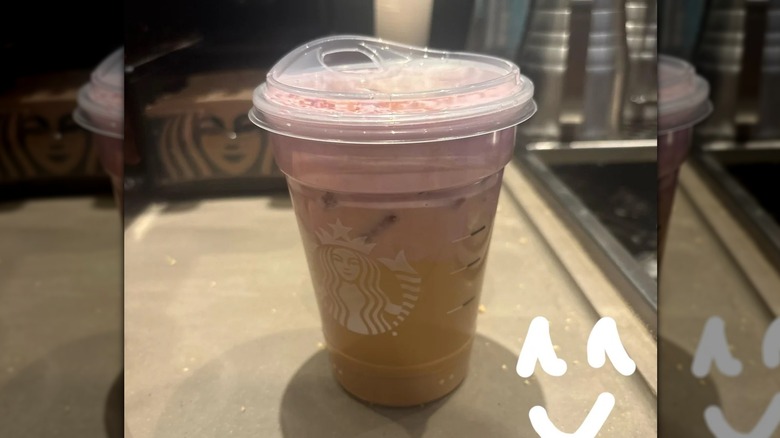 A pink and brown iced Starbucks drink on a kitchen counter