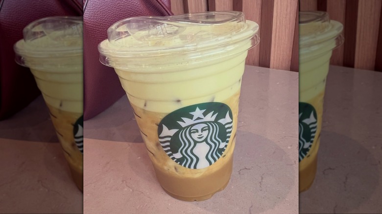 A short iced coffee drink from Starbucks, half green and half brown