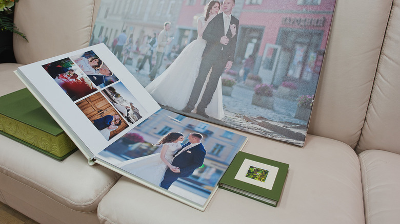 Green and white leather wedding photo book with print enlargement in the background.