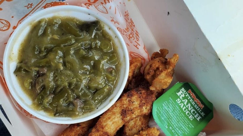Popeyes Green Beans next to some chicken tenders and ranch sauce