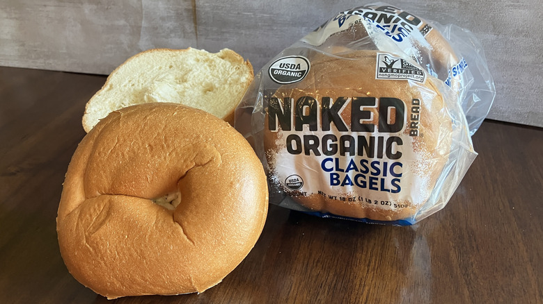 Bagel from Naked Organic brand displayed on table in front of a sleeve of the bagels in bag.