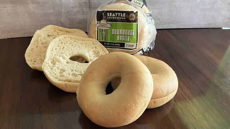 Bagels displayed in front of a bag of Seattle Sourdough Baking Company bagels on table.