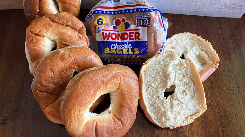 Misshapen bagels form a ring around a bag of Wonder bagels on a table.