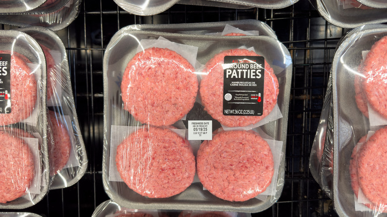 Packages of ground beef patties on a grocery store shelf