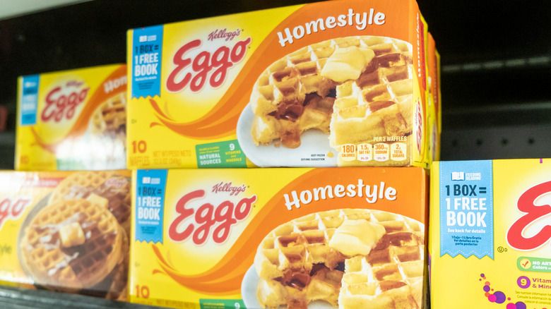 Several yellow boxes of Eggo waffles sitting on a store shelf.