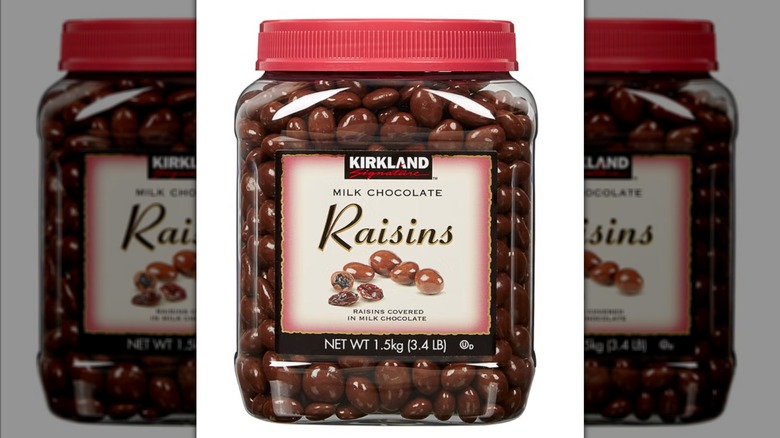Plastic container of Kirkland Signature Milk Chocolate Raisins on white background
