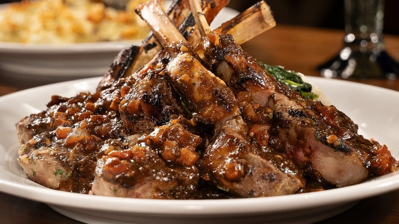 A plate heaped with lamb chops drizzled with sauce