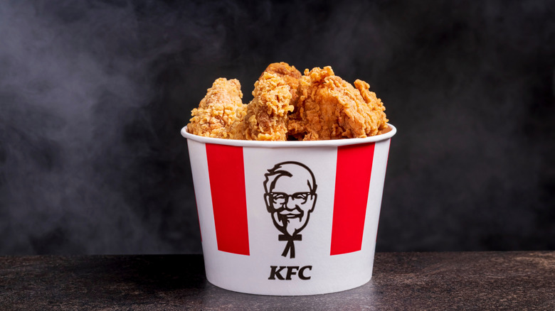 A bucket of KFC chicken sits on a surface