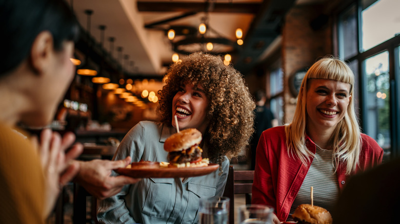 Woman being served a burger at a restaurant