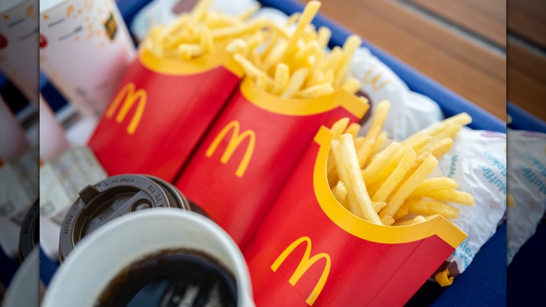 McDonald's fries sit on a tray with a variety of beverages
