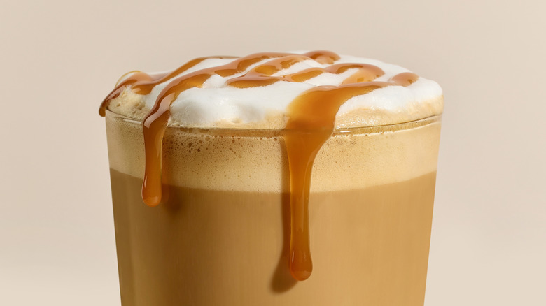 glass of caramel frappe with caramel dripping down the sides of glass