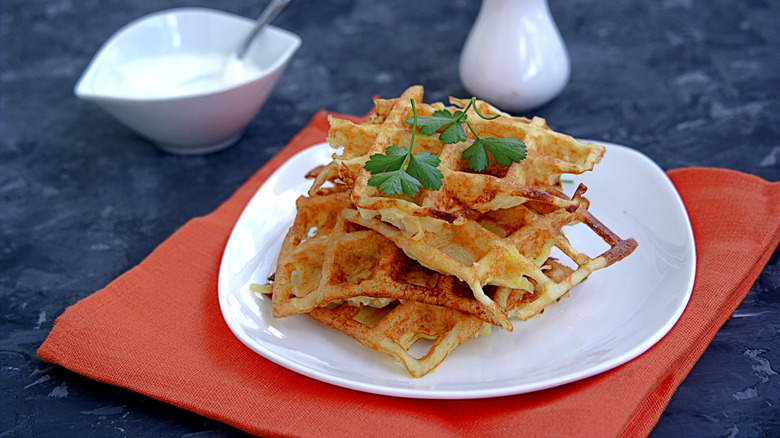 crispy hashbrowns made in a waffle maker served on a plate with condiments on the side
