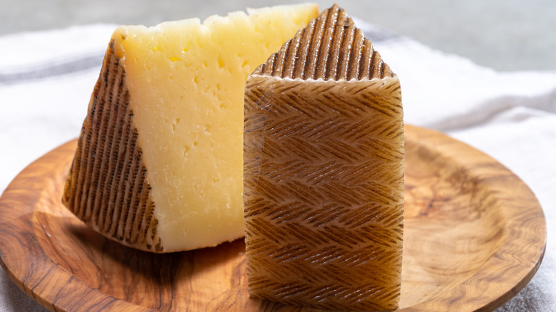 Wedges of manchego cheese on a wood plate