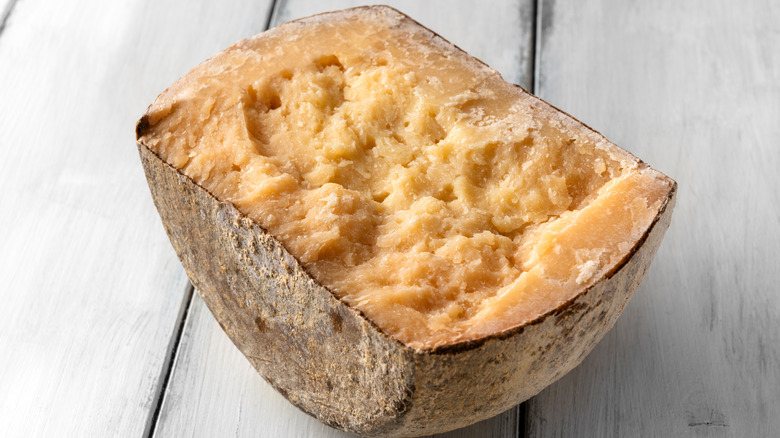 Pecorino sardo cheese on a wood background