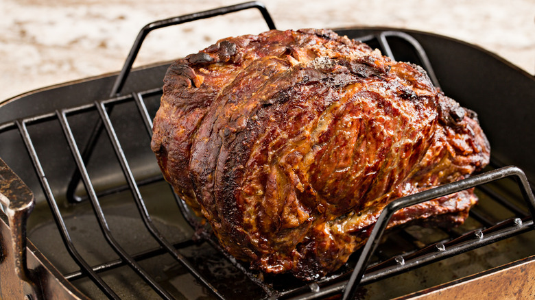 Roasted prime rib with a dark crust in a baking pan