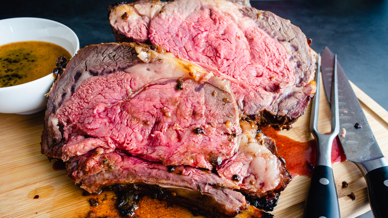 Well marbled slices of fatty prime rib cooked medium rare on a cutting board
