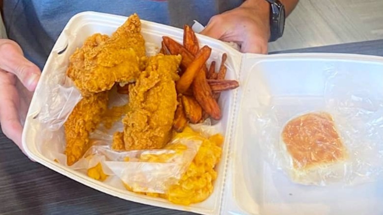 Publix chicken tenders with potato wedges, mac and cheese, and a roll in a styrofoam container