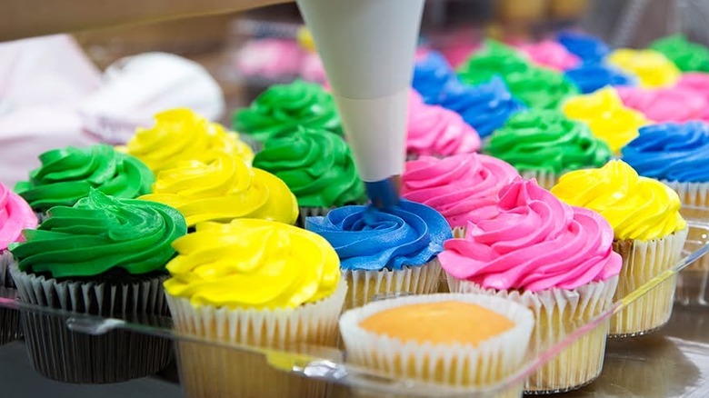 Assorted Publix cupcakes with green, yellow, and pink-colored icing