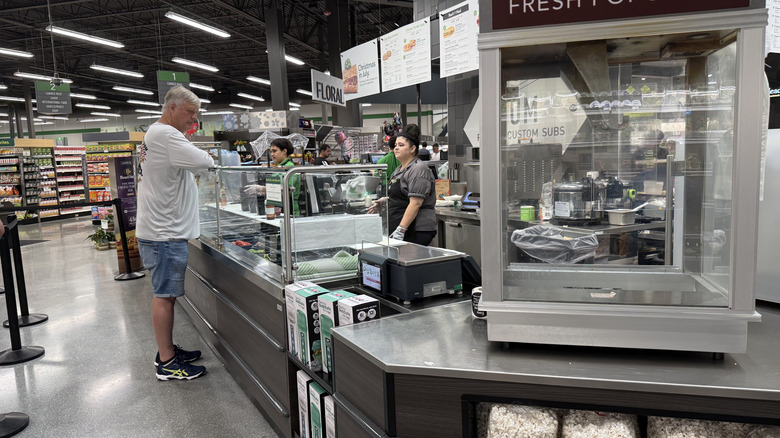 Publix sub and sandwich counter with customer talking to employee