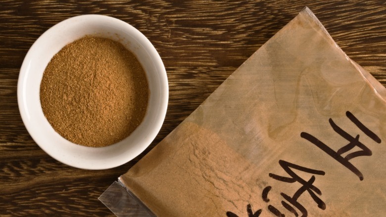 A close-up of Chinese five spice powder in a white bowl.