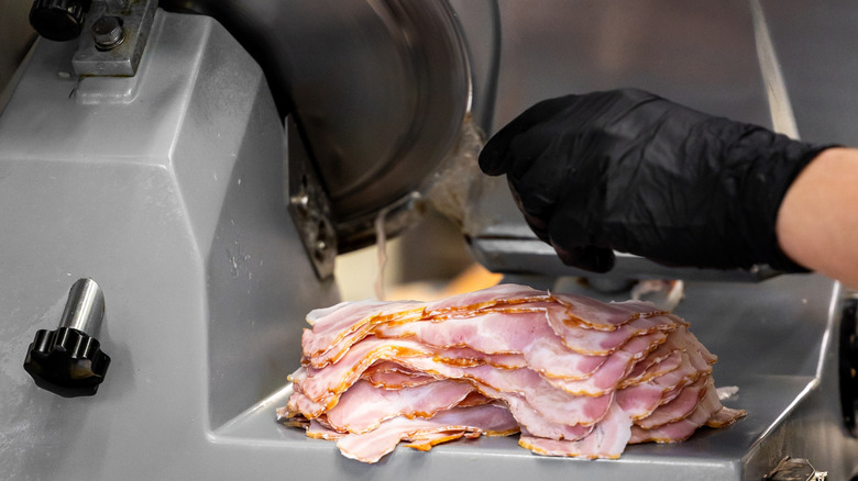 Close up of meat slicer with slices of ham