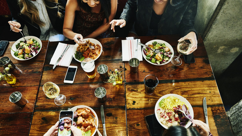 A table set with food and drinks with diners eating