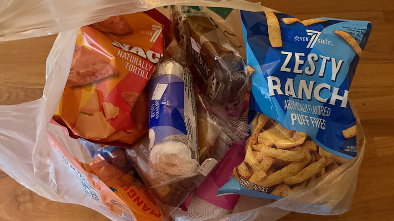 A plastic shopping bag full of 7-Eleven snack foods