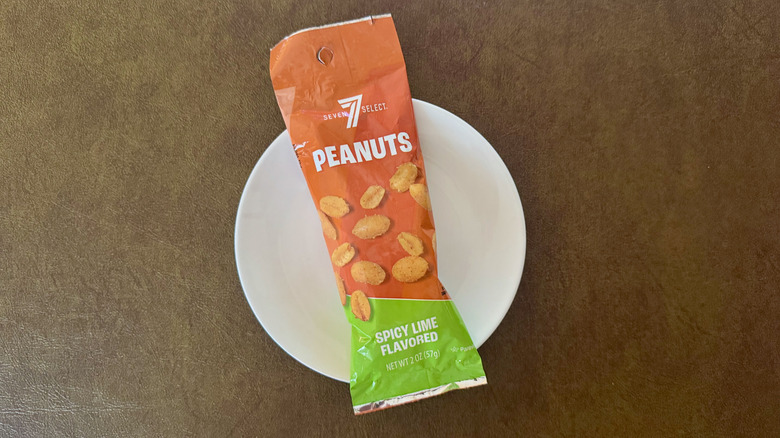 An orange and green package of 7-Select peanuts on a small white plate