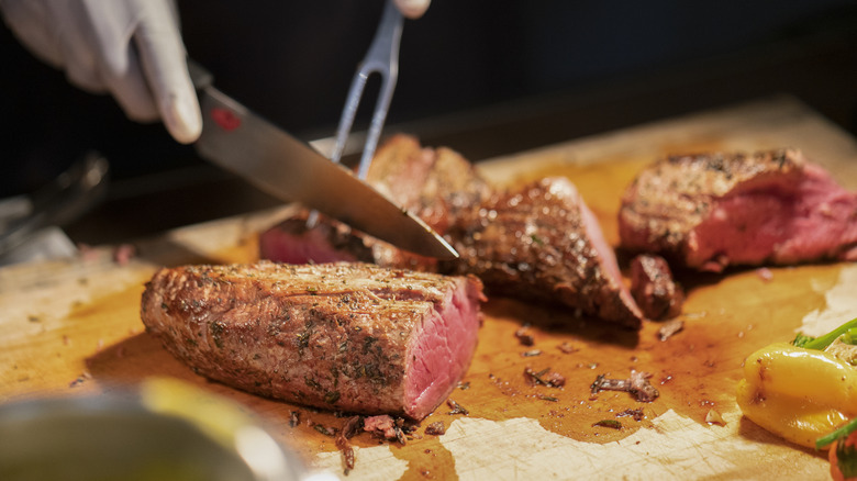 A rare steak being carved at a station