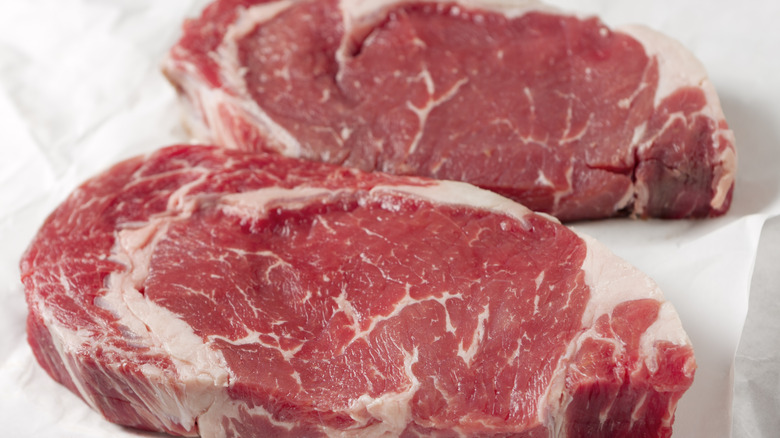 Raw ribeye steaks on butcher paper
