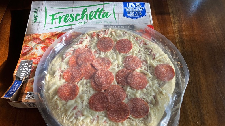 Frozen pepperoni pizza atop a Freschetta brand pizza box.